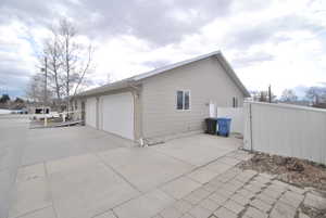 View of side of property featuring driveway and fence.  Three car garage with 1 spot that can be dedicated to the downstairs ADU if needed.