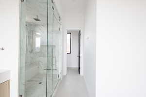 Full bathroom featuring a marble finish shower, baseboards, and vanity