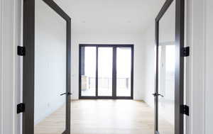 Hallway featuring french doors and light wood-type flooring