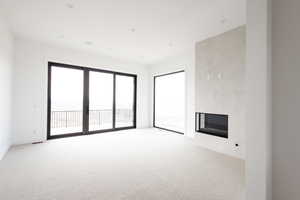 Unfurnished living room with a fireplace and light carpet