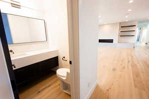 Bathroom featuring vanity, recessed lighting, wood finished floors, and toilet