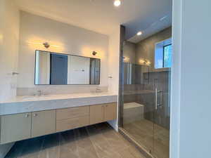 Full bathroom with double vanity, a stall shower, and recessed lighting