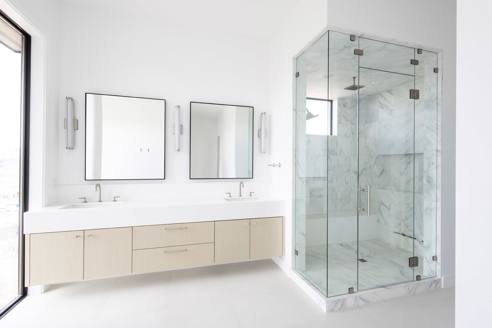 Full bath featuring double vanity, a marble finish shower, and a sink
