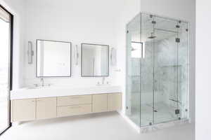 Full bath featuring double vanity, a marble finish shower, and a sink