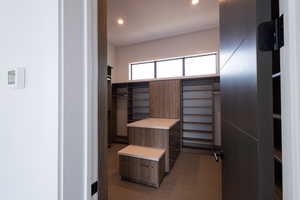 Spacious closet with dark colored carpet