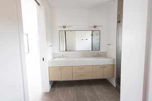 Bathroom with a sink, double vanity, and marble finish floor