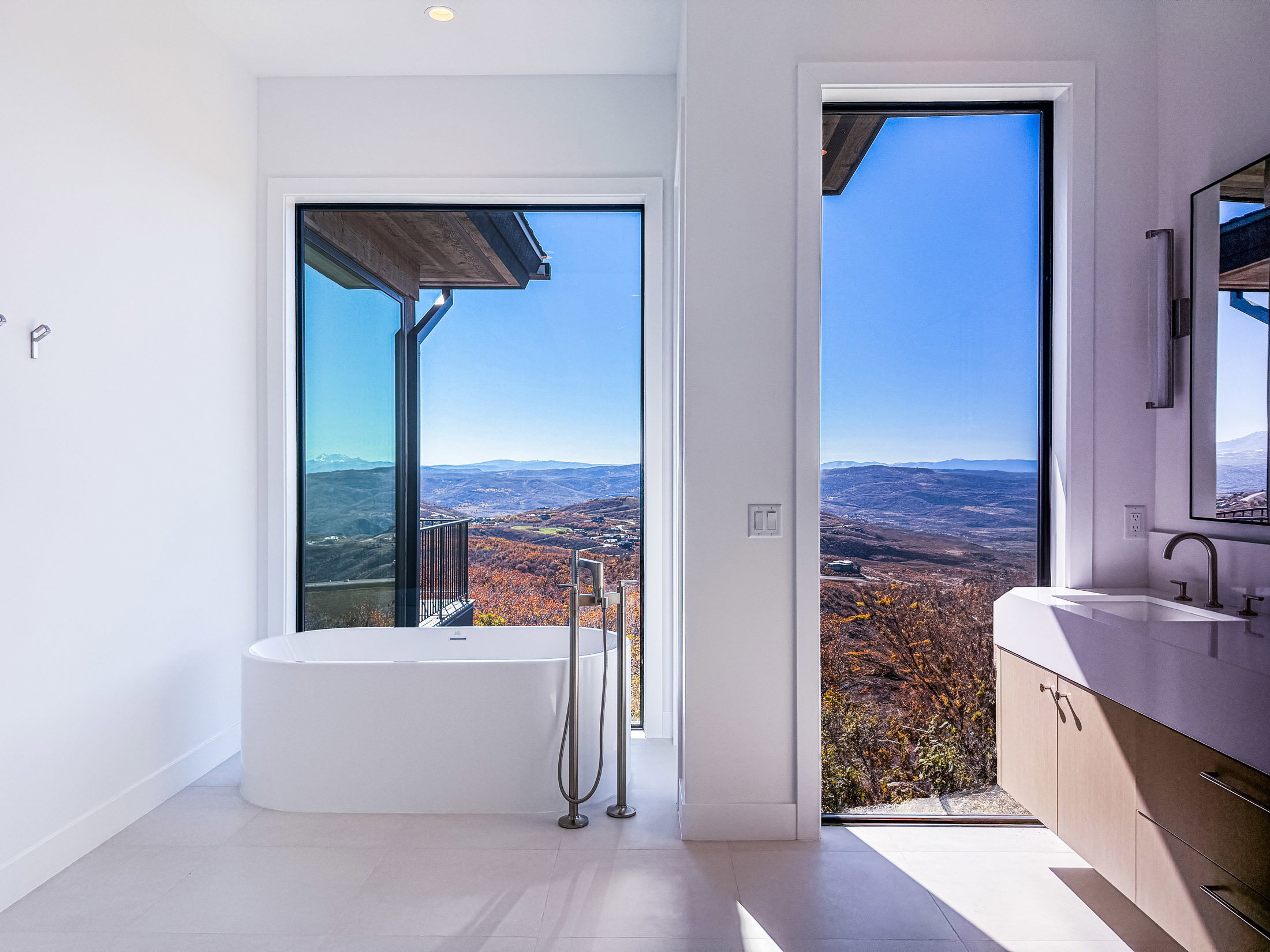 Bathroom with a mountain view, a soaking tub, vanity, and light tile patterned floors