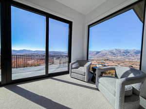 Living area with a mountain view and carpet flooring