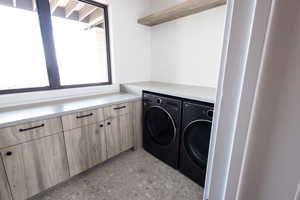 Washroom featuring independent washer and dryer and cabinet space