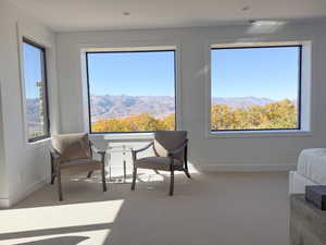 Sitting room with a mountain view, carpet flooring, and healthy amount of natural light