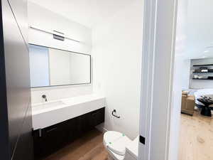 Half bathroom with light wood finished floors and vanity