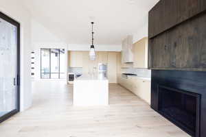 Kitchen featuring light countertops, appliances with stainless steel finishes, backsplash, and light wood-type flooring