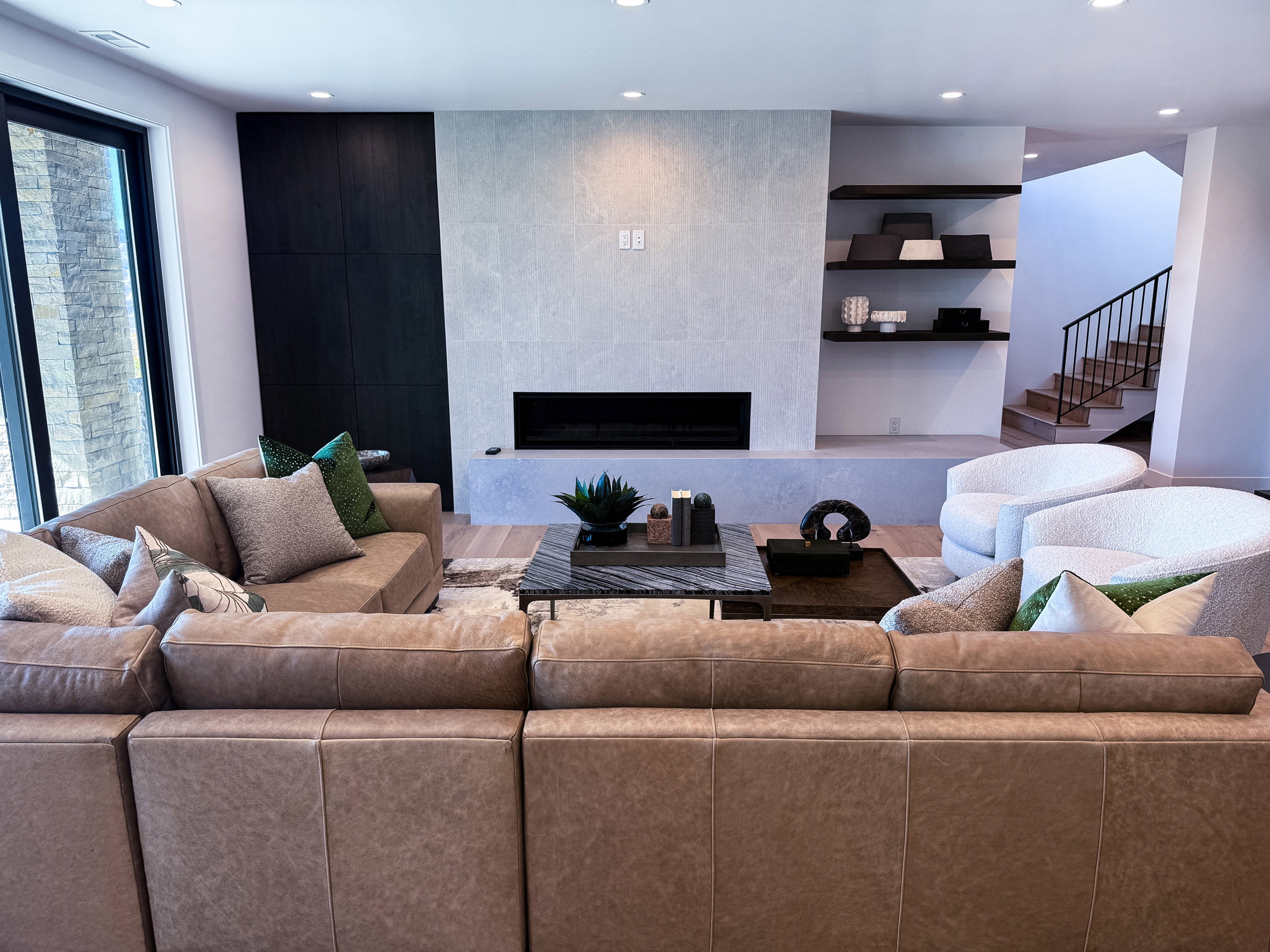 Living room with a tiled fireplace, recessed lighting, stairs, and built in features