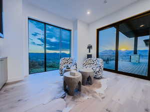 Sitting room with a mountain view, light wood finished floors, and recessed lighting