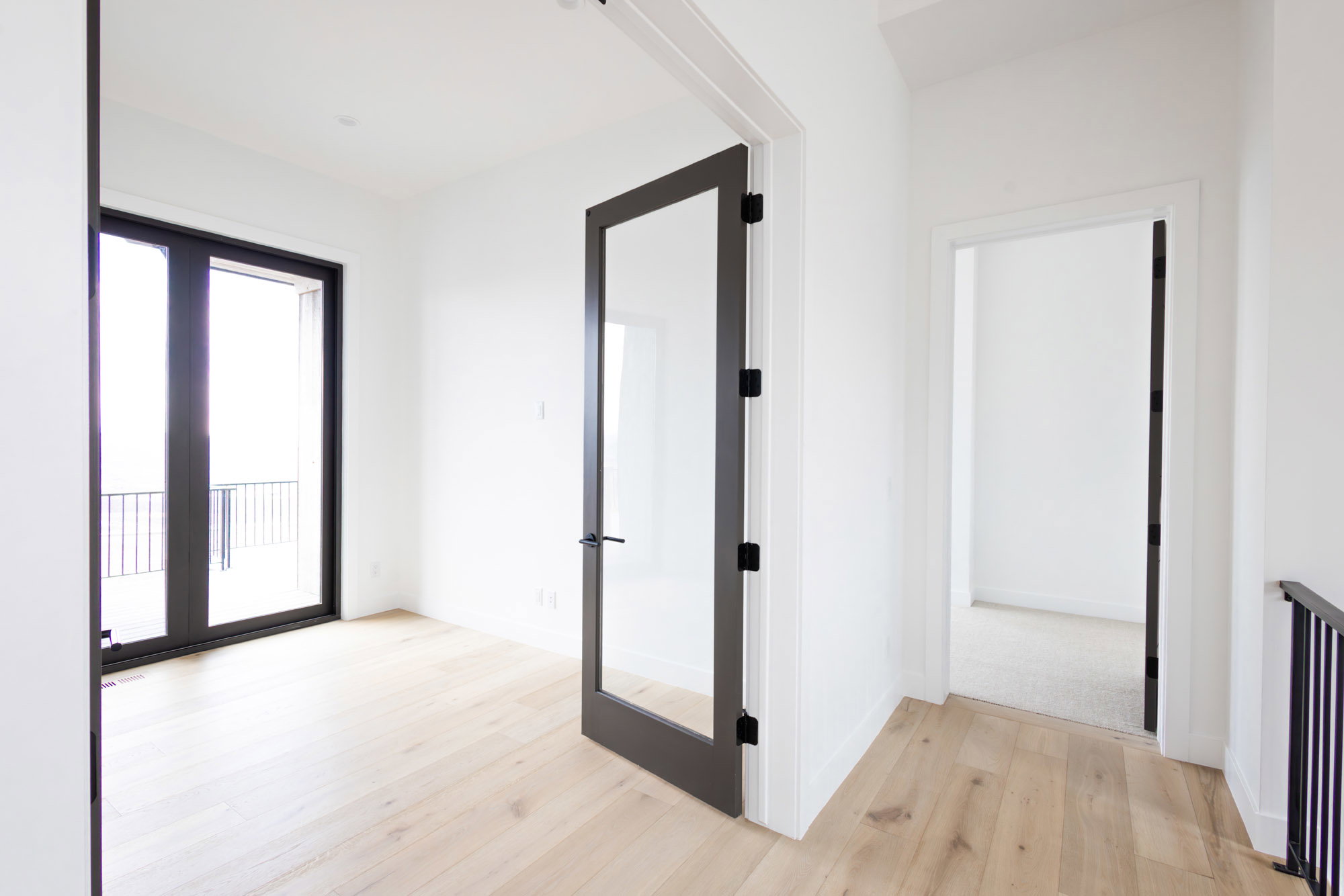 Corridor featuring french doors, light wood finished floors, and baseboards