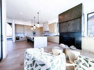 Kitchen featuring pendant lighting, an island with sink, modern cabinets, healthy amount of natural light, and recessed lighting
