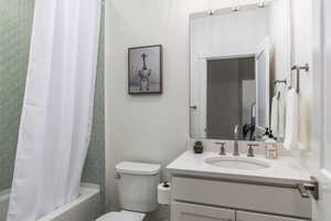 Full bath with toilet, vanity, and shower / bathtub combination with curtain
