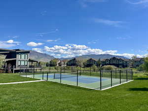 View of tennis court with a mountain view and a residential view