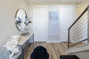 Foyer entrance with stairway and light wood-style floors