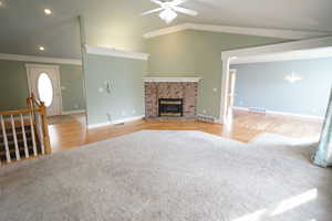 Unfurnished living room featuring visible vents, carpet, a fireplace, and ceiling fan with notable chandelier