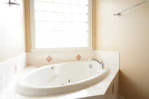 Full bathroom with a tub with jets
