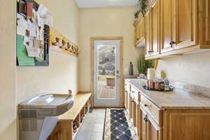 Mudroom featuring light countertops, open shelves, and a sink