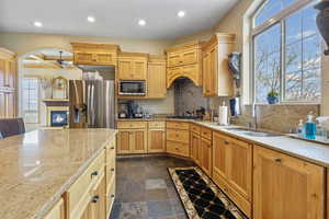 Kitchen with recessed lighting, stone tile flooring, plenty of natural light, stainless steel appliances, and a sink