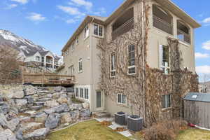 Rear view of property with central AC unit, an outdoor structure, and stucco siding