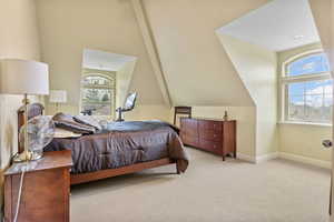 Bedroom with baseboards, carpet floors, and vaulted ceiling