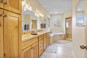 Bathroom featuring tile patterned floors, a stall shower, a bath, and a sink