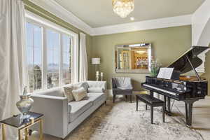 Living area with crown molding, baseboards, and a chandelier