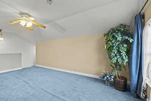 Additional living space with baseboards, ceiling fan, carpet, and lofted ceiling