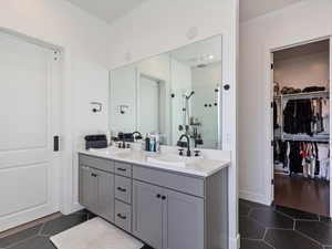 Bathroom featuring a shower stall, tile patterned flooring, and a sink