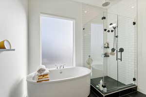 Full bath featuring a shower stall and a freestanding bath