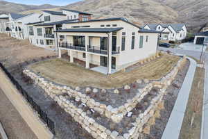 Exterior space with a balcony, fence, a residential view, stucco siding, and a mountain view