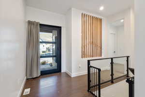 Entrance foyer featuring dark wood-style floors, visible vents, recessed lighting, and baseboards