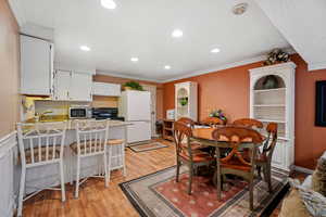 Dining space featuring baseboards, ornamental molding, recessed lighting, and light wood-type flooring