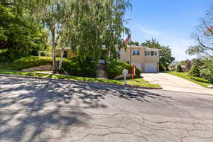 View of front of home featuring concrete driveway, an attached garage, and stairs