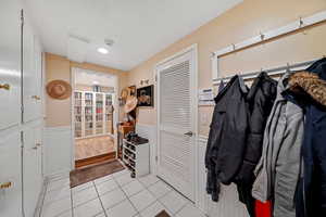 Interior space featuring a wainscoted wall and light tile patterned floors