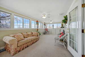Sunroom featuring carpet flooring, a ceiling fan, and crown molding