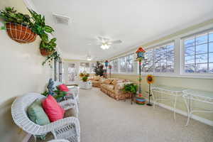 Sunroom / solarium featuring carpet flooring, ornamental molding, an outdoor living space, and ceiling fan