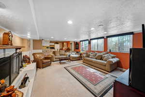 Carpeted living room featuring recessed lighting, a fireplace, and a textured ceiling