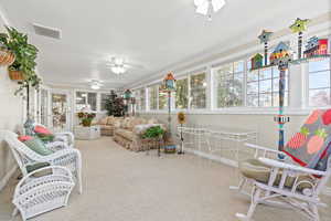 Sunroom / solarium featuring carpet and crown molding