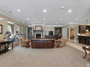 Living room featuring a tile fireplace, light carpet, a textured ceiling, visible vents, and recessed lighting