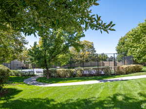 View of home's community with fence and a lawn