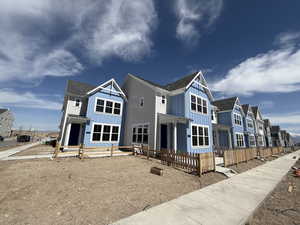 Back of house with board and batten siding, fence, and a residential view