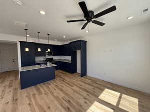 Kitchen featuring visible vents, ceiling fan, appliances with stainless steel finishes, light wood-type flooring, and light stone countertops