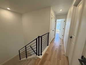 Hallway featuring recessed lighting, an upstairs landing, light wood-style floors, and baseboards