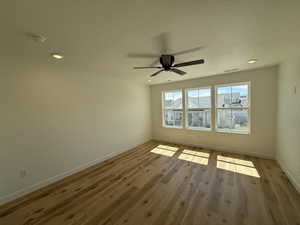 Empty room with visible vents, baseboards, a ceiling fan, recessed lighting, and wood finished floors