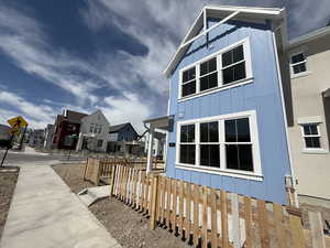View of side of property featuring board and batten siding, fence, and a residential view